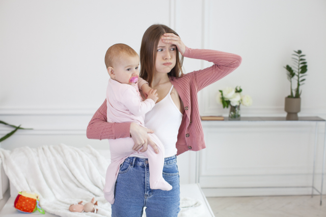 tired mom holding a baby