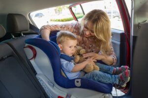 mom putting the kid in car seat